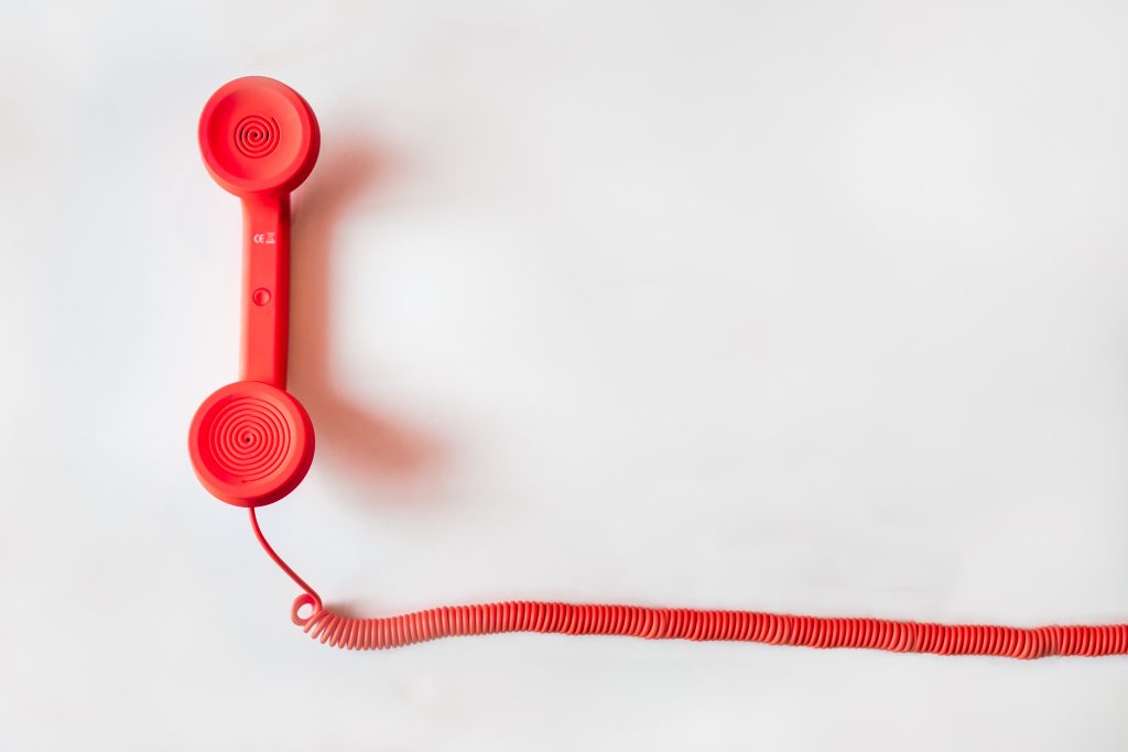 Um telefone com fio sobre um fundo branco, referindo-se à boa comunicação necessária na questão de como administrar sua marcenaria