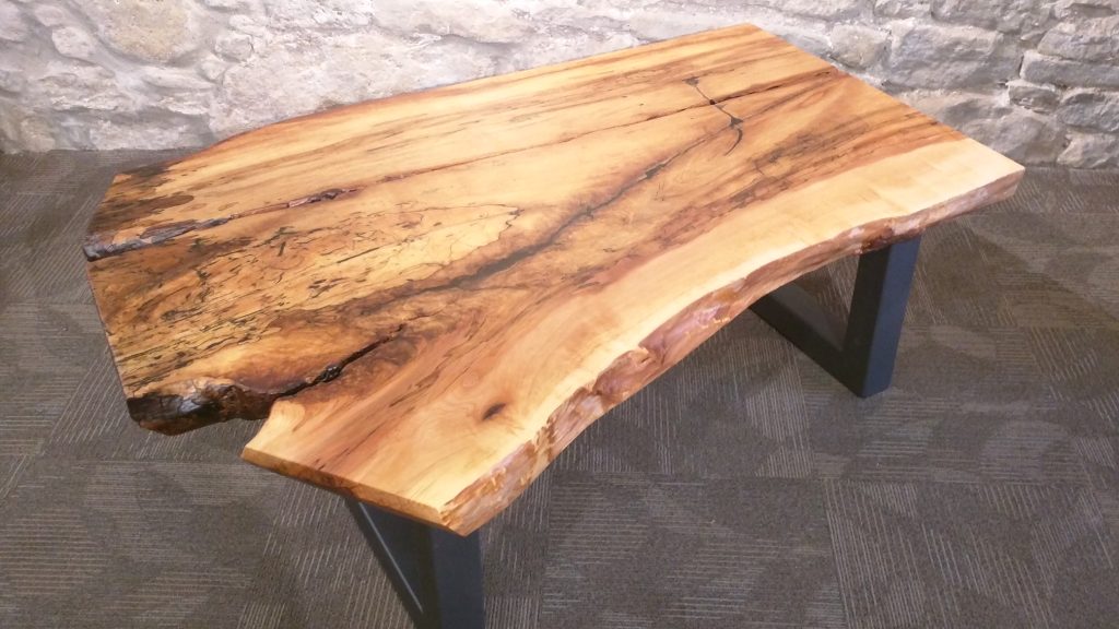 Uma mesa de centro produzida com madeira para área externa de reflorestamento.